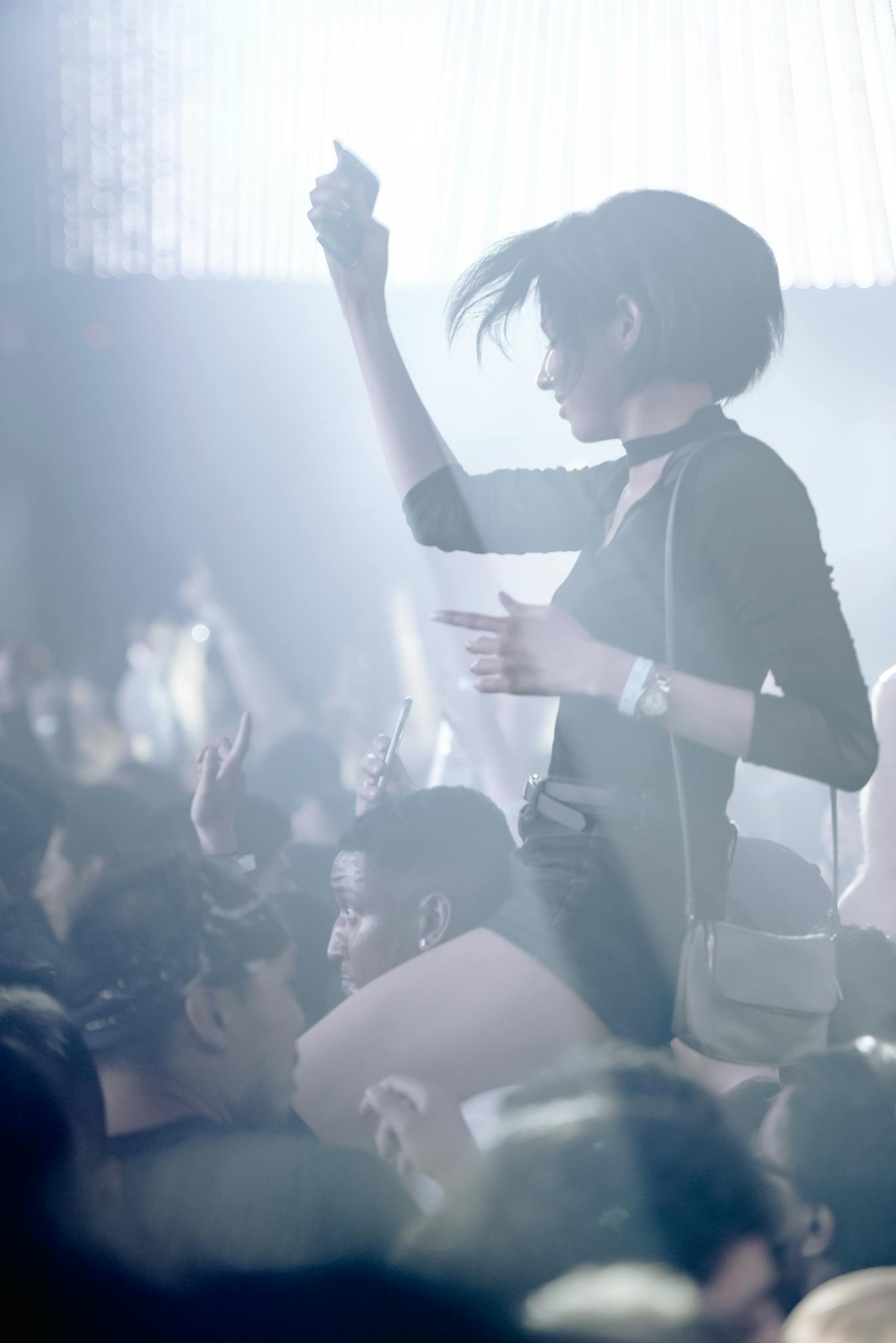 Lively nightclub atmosphere with people enjoying music and dance. High energy and vibrant lights.